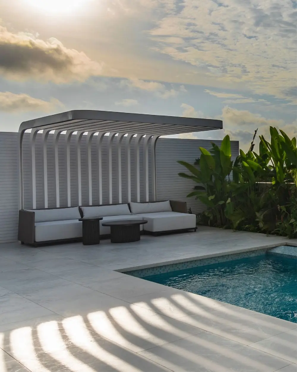 Teras berjemur dengan lounge pergola di tepi kolam